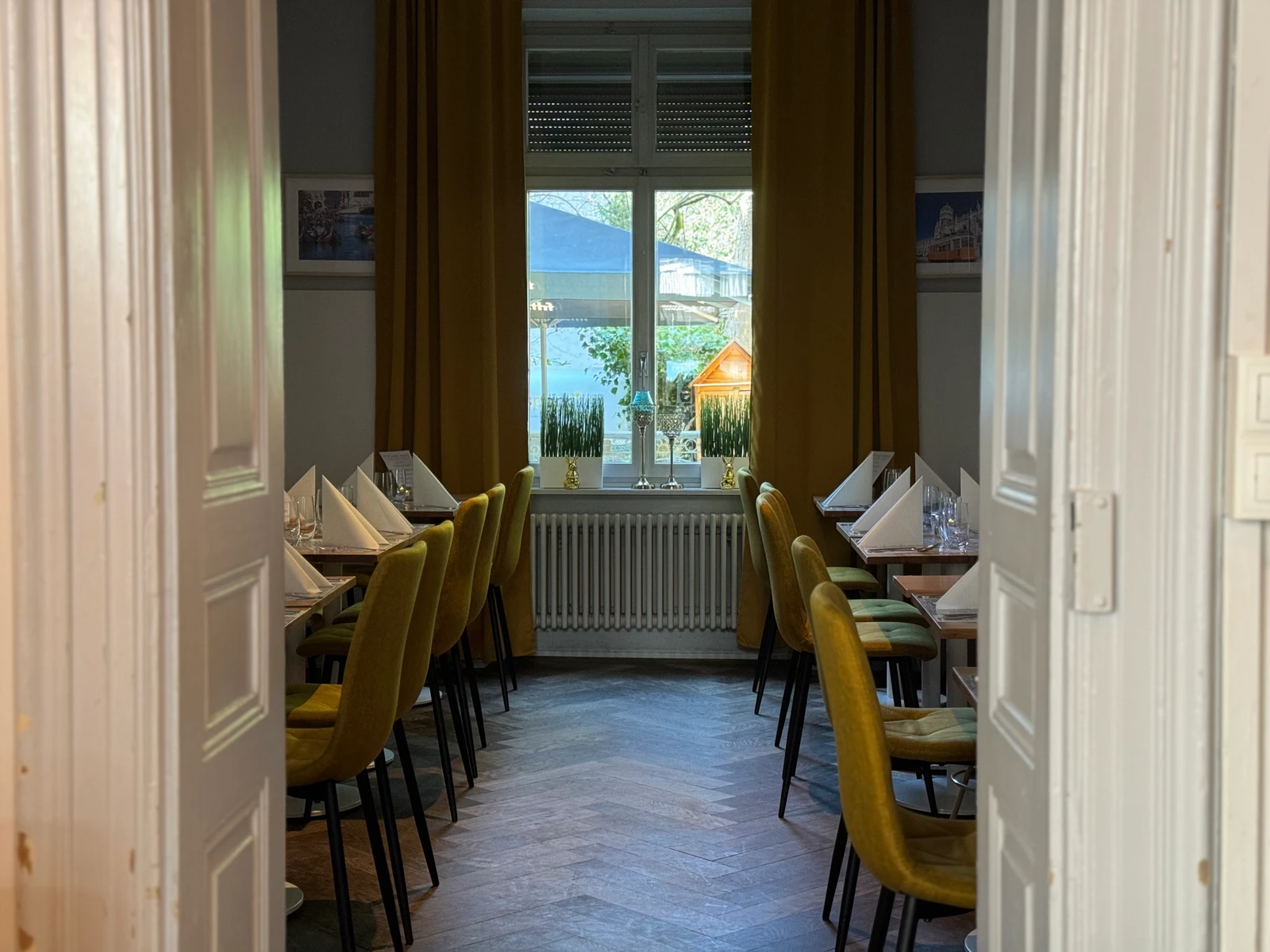 Eleganter Speisesaal mit goldenen Samtfauteuils und Parkettboden
